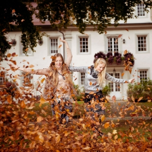Modefotografie in herbstlichen Blätter im Schlosspark